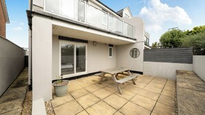 A residential property with a patio, a sliding glass door, and a small garden area. - Spacious 3 Bed House - Sleeps 6 - Parking - Wifi (Newquay)