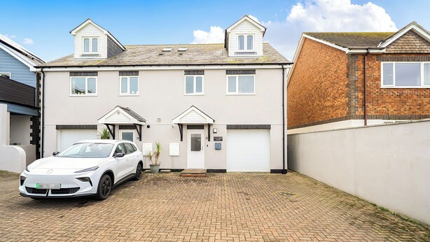 A two-story residential building with a car parked in the driveway. - Spacious 3 Bed House - Sleeps 6 - Parking - Wifi (Newquay)
