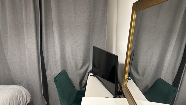 A room with a bed, a desk with a computer, a chair, and a large mirror. - Great 5-bed Wembley Home 25min From Central London (Harrow)