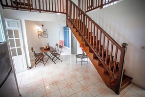 Enjoy meals in the central dining area with a wooden table and chairs.
