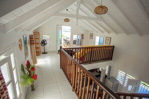 Stunning interior with high ceiling, wooden beams, and a spacious staircase leading to an upper level.