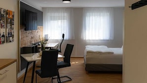 A compact room with a bed, a desk, and a chair. - New Age Boardinghaus Bad Wimpfen (Bad Wimpfen)