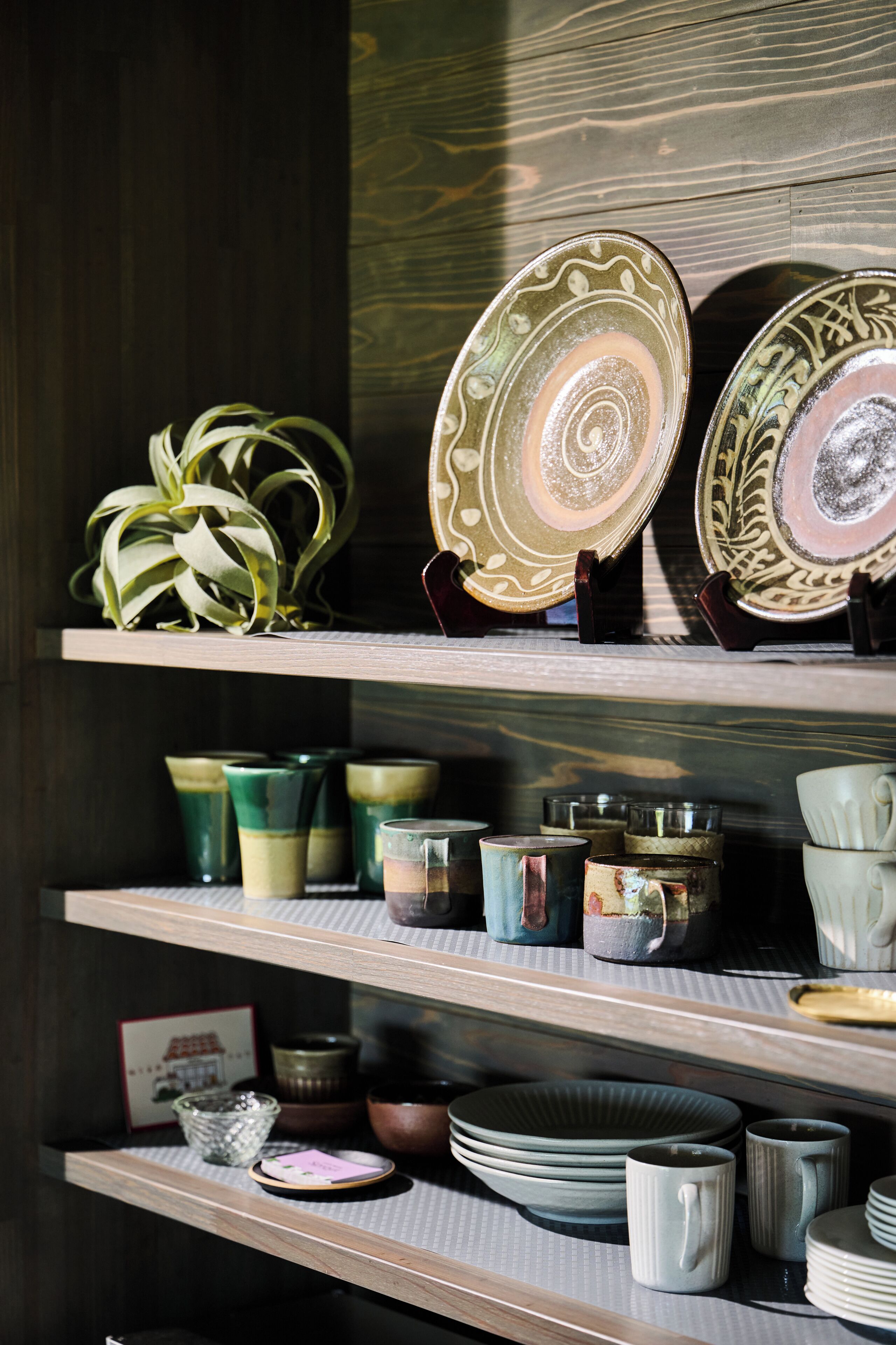 Shelves with various ceramic items including plates, cups, and bowls.