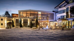 Un edificio moderno con grandes ventanales y un patio cubierto de nieve.