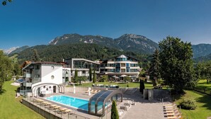 Un hotel con piscina, varias habitaciones y vistas a la montaña.