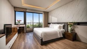 Una habitación de hotel moderna con una cama grande, un escritorio y vistas a la ciudad.