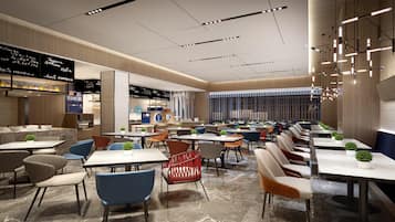 Un restaurante moderno con varias zonas de comedor, incluyendo un bar y un espacio con mesas y sillas.