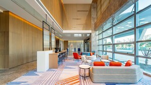 A spacious lobby with a high ceiling, modern furniture, and large windows offering views of the outdoors. - Holiday Inn Express Suzhou Bay (Suzhou)