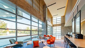 A spacious lobby with large windows, a seating area with various chairs and tables, and a reception desk. - Holiday Inn Express Suzhou Bay (Suzhou)