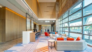 A spacious lobby with a high ceiling, modern furniture, and large windows offering views of the outdoors. - Holiday Inn Express Suzhou Bay (Suzhou)