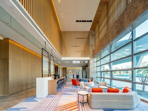 A spacious lobby with a high ceiling, modern furniture, and large windows offering views of the outdoors. - Holiday Inn Express Suzhou Bay (Suzhou)