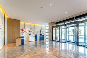 A modern lobby with a marble floor, glass doors, and two reception desks. - Holiday Inn Express Suzhou Bay (Suzhou)