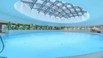 Una piscina techada, sillones reclinables de piscina