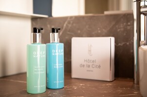 Duas embalagens de loção corporal Deep Nature e uma caixa branca com o texto 'Hôtel de la Cité'.