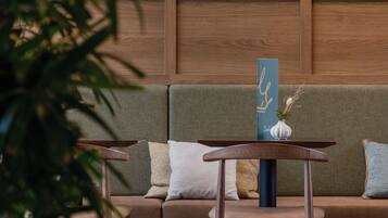 A modern interior with a wooden bench, a cushioned seating area, and a stone wall.