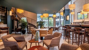Un interior moderno con una escalera, zona de estar y bar.