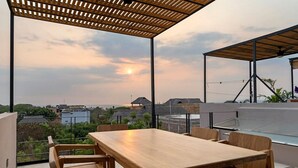 A wooden table and chairs under a pergola with a sunset view. - Quiet La Punta Surf Villa (Santa María Colotepec)