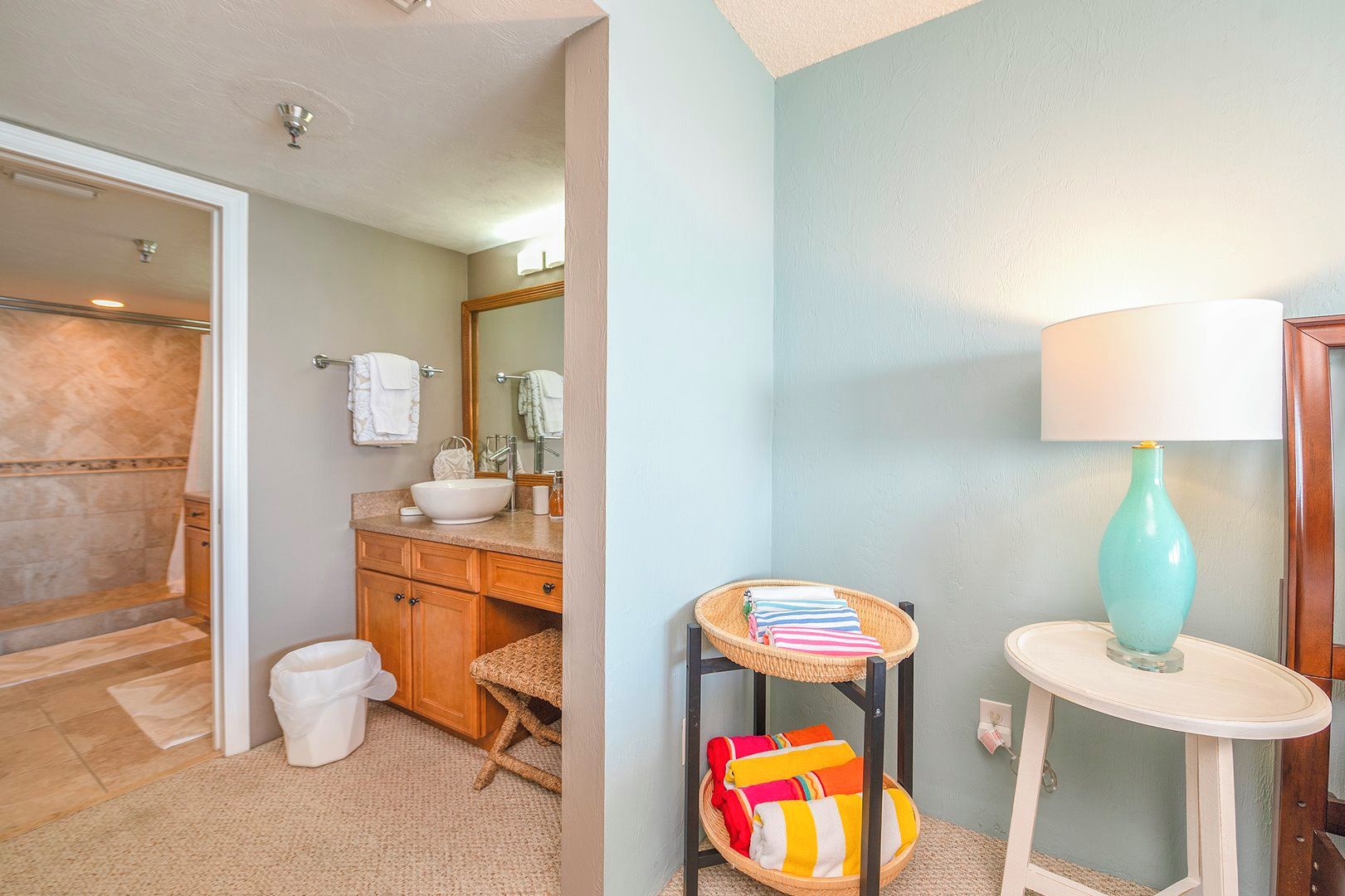 A bathroom with a sink, mirror, and towel rack.