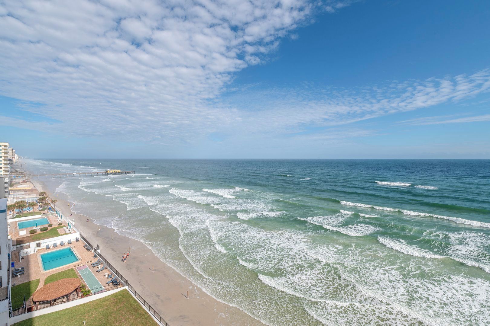 Een strandhotel met zwembad, toegang tot het strand en uitzicht op de oceaan.