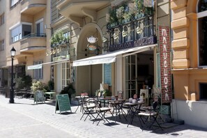 A café with outdoor seating, a sign reading "MARVELOLO MARVELO," and a menu board.