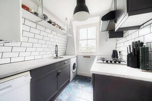 Enjoy cooking in this well-lit kitchen with a stainless steel sink, oven, and modern backsplash.
