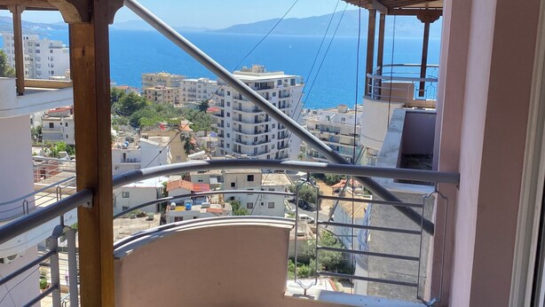 Un balcon avec vue sur la mer et les bâtiments.