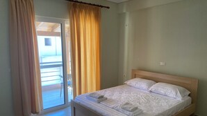 Une chambre à coucher avec un lit, une fenêtre avec des rideaux et une vue sur l’extérieur.