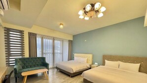 Una habitación de hotel con dos camas, un sofá, un banco y un escritorio.