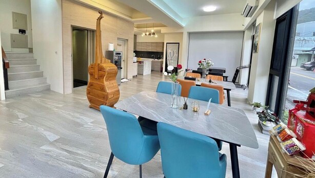 Un comedor moderno con una mesa de mármol, sillas azules y un aparador de madera.