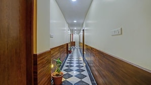 Un pasillo con paneles de madera, suelo de cuadros y una planta en maceta.