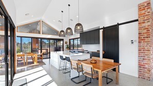 A modern kitchen with a large island, dark cabinetry, and pendant lighting. - Buller Peeps  - Mansfield (Mansfield)