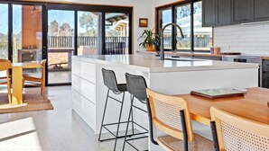 A modern kitchen with a large island, bar stools, and a view of the outdoors. - Buller Peeps  - Mansfield (Mansfield)