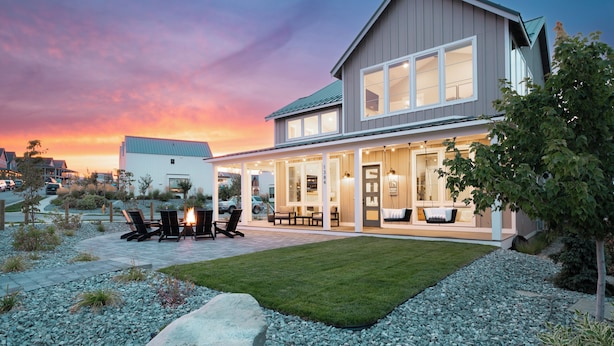 A modern two-story house with a patio area featuring outdoor furniture and a fire pit. - Bighorn & Bluebell at Chelan Lookout Vacation Rentals (Chelan)