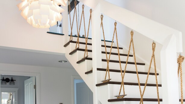 Un escalier à l’intérieur blanc, doté d’un design original en forme de corde.