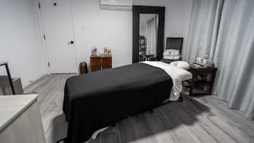 Relax in a serene space with a comfortable bed, desk, and mirror.