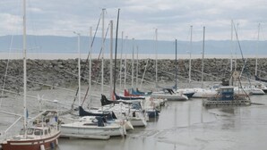 A marina with multiple boats docked, a rocky shoreline, and a distant mountain range. - Distinctive 5-room inn, located a few steps from the river to discover the multi (SAINT JEAN PORT JOLI)