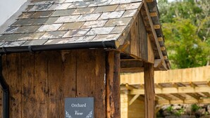 A rustic wooden structure with a sign reading 'Orchard View.'
