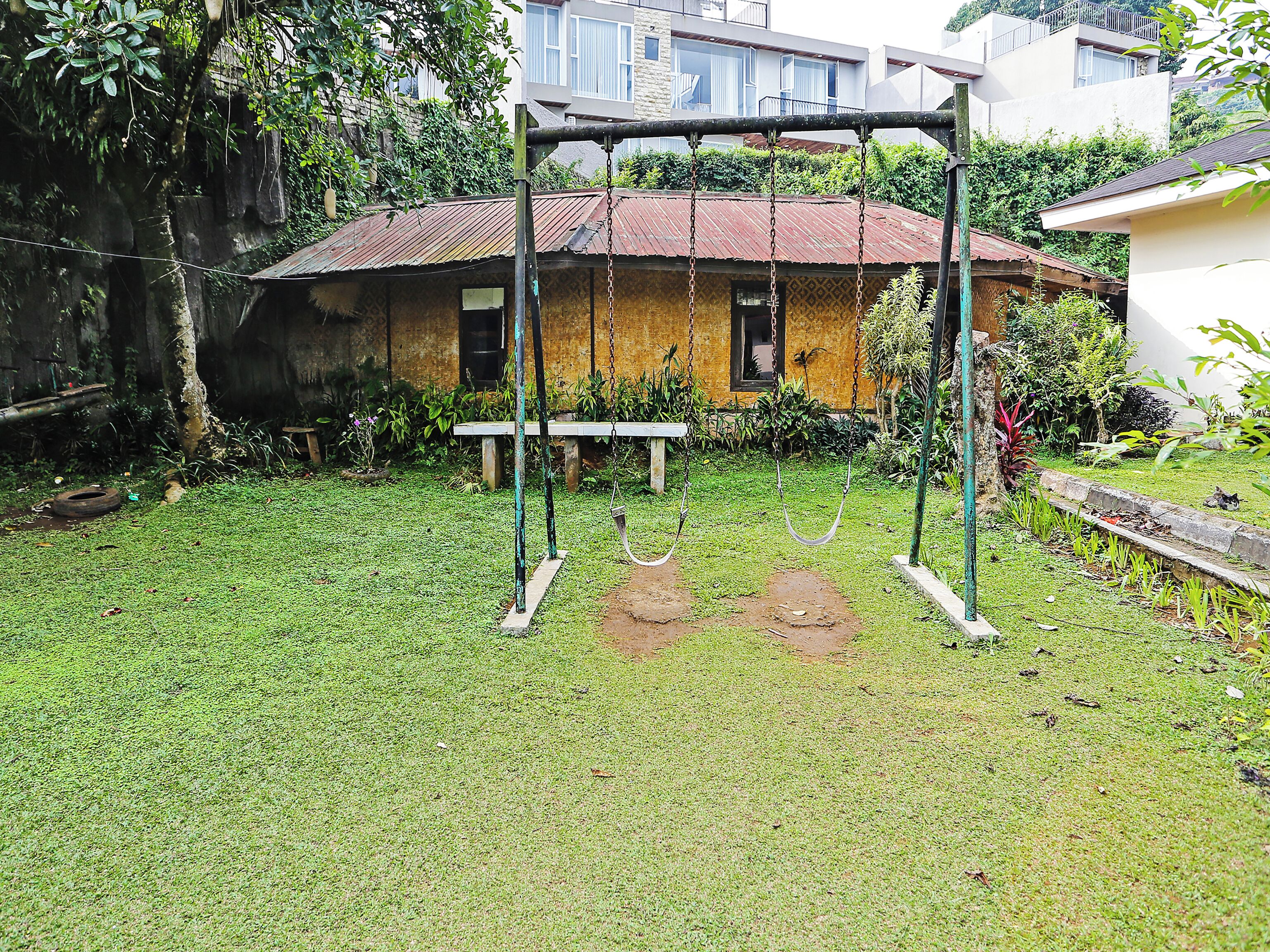 Una casa de madera rústica con un columpio en el jardín.