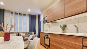 Eine moderne Küche mit Holzausstattung, einer Marmorarbeitsplatte und einem eingebauten Backofen.