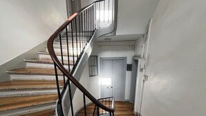 A spiral staircase with wooden steps and a metal railing. - Urban Flat 94 - Sublime 4BDR Flat Coco Chanel (París)