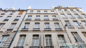 A multi-story building with a classic architectural style, featuring symmetrical windows and ornate balcony railings. - Urban Flat  117 - Charming 3BDR Apartment in Paris (París)