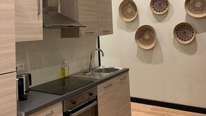 A modern kitchen with wooden cabinets, a stainless steel sink, and a built-in oven. - Urban Flat 159 - Charming 3BDR Flat in Paris (París)