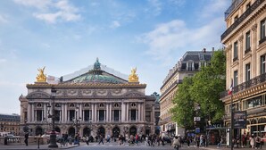 A large, historic building with a prominent dome and statues, surrounded by a busy urban street with pedestrians and shops. - Urban Flat 159 - Charming 3BDR Flat in Paris (París)