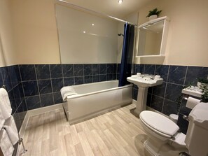 Une salle de bain moderne avec une baignoire, des toilettes et un lavabo.