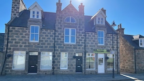 A stone building with a sign for "Mane Attraction." - Deeside Snugs (Aboyne)