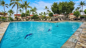 A swimming pool with lounge chairs and palm trees. - Keauhou Kona Surf & Racquet 1104: Ocean Views, Resort Amenities & Prime Location (Kailua Kona)