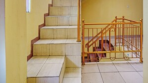 Un escalier avec une rampe en bois et une porte en métal en bas.