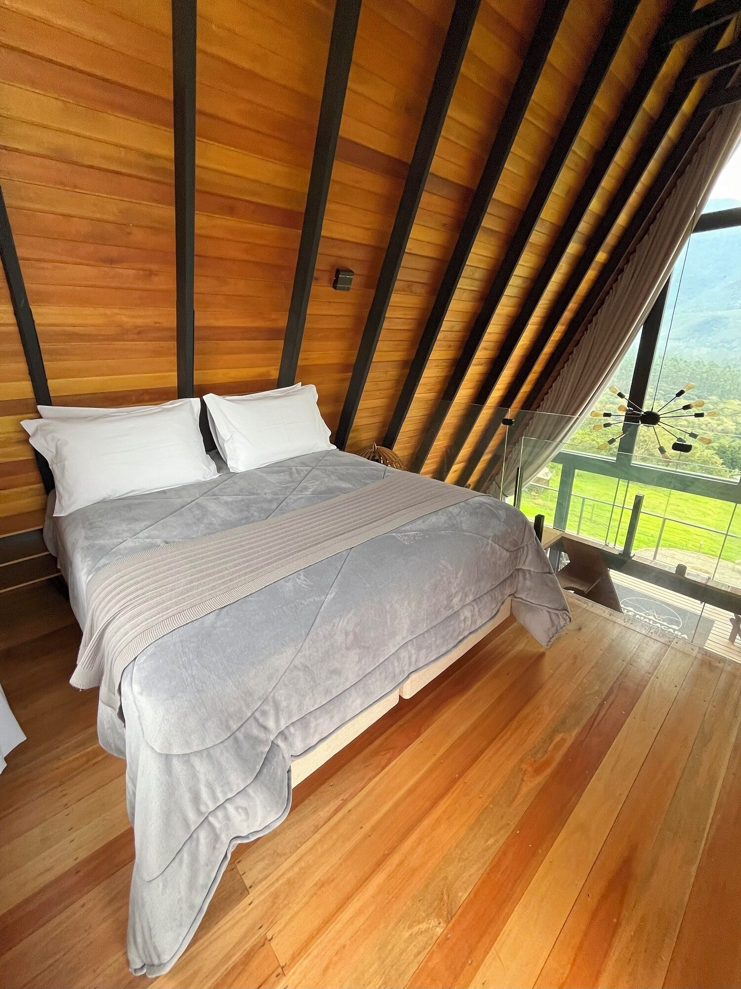 A bedroom with a wooden ceiling and a large bed.