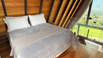 A bedroom with a wooden ceiling and a large bed.