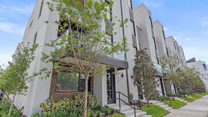 A modern building with a unique architectural design, featuring a combination of glass and concrete materials. - Uptown Luxury On Audubon 4 Bedroom Townhouse by RedAwning (Sarasota)